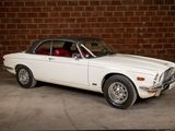 a white car that is parked in front of a brick wall