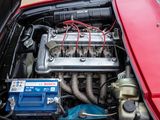a red car engine with a blue battery in it