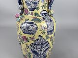 a yellow vase with blue and white designs on it
