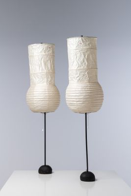 deux lampes blanches posées sur une table blanche, sur fond gris