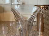 un vase en verre posé sur un plan de travail, à côté d'autres vases en verre