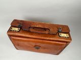 a small brown suitcase sitting on top of a white table