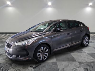 the grey car is parked on a checkered floor in the garage
