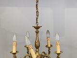 a gold chandelier with five lights hanging from it