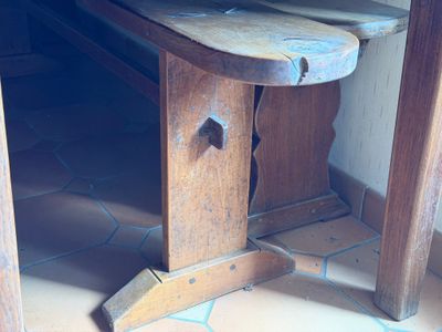 une table en bois avec un banc en dessous, dans une pièce