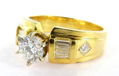 une photo d'une bague en or sertie d'un diamant et de diamants taille baguette