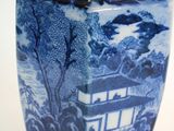 a blue and white vase with a picture of a boat in the water
