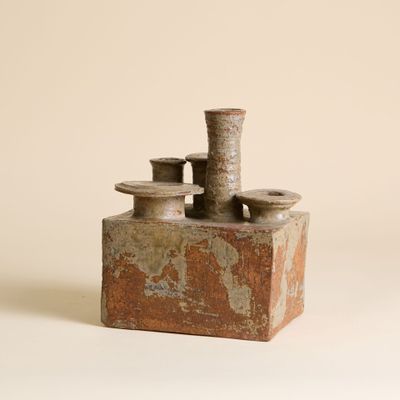 un petit objet en poterie posé sur une table