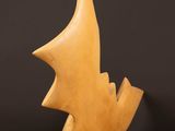 a wooden sculpture of a fish on a stand on a wooden floor