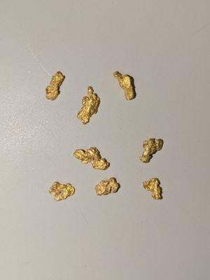 quelques pépites d'or sont éparpillées sur une surface blanche