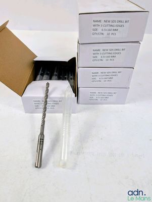 a box of drill bits sitting on a table next to a box of drill bits