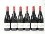 six bouteilles de vin rouge sont alignées sur une surface blanche