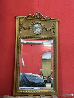 un miroir posé sur une table sur laquelle se trouve une horloge