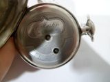 une personne tenant une montre de poche en argent à la main