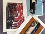 four cards of old cars are sitting on a table next to a pair of scissors and a pair of scissors