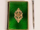 a small green box with a gold broocher on it