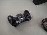 a black game controller sitting on a table next to a mouse