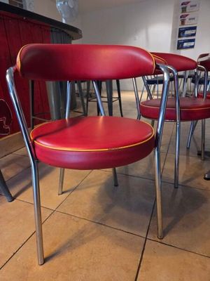 Plusieurs chaises rouges sont alignées en rangée dans un restaurant