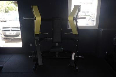 une photo d'une salle de sport avec un banc et une barre de traction