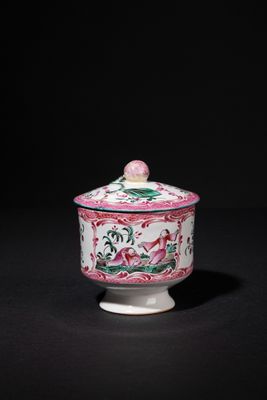 a pink and white bowl with a lid on a black surface