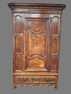 une vieille armoire en bois avec une porte et un tiroir sur le dessus