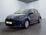 une Toyota Yaris bleue garée dans une pièce blanche