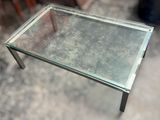 a glass table with a metal base and a glass top