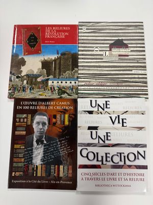 Trois livres sont posés sur une table, à côté d'une tasse de café
