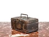 une vieille valise posée sur une table, sur fond blanc