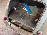 a suitcase in the trunk of an old car