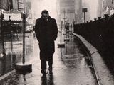 a man walking down the street in the rain