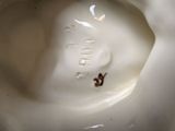 a close up view of a white vase with a brown bug on it