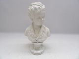 a white bust of a young boy on a glass stand