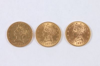 Trois types différents de pièces d'or sont représentés sur un fond blanc