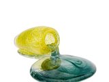 a yellow and green glass object sitting on top of a blue plate