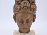 une image représentant une sculpture représentant une tête de femme posée sur un socle en marbre