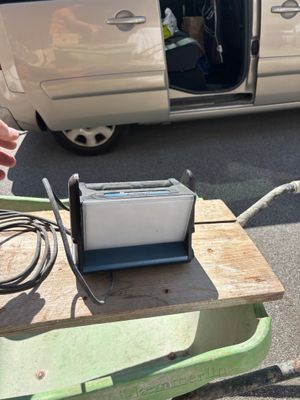 un homme debout à côté d'une table sur laquelle se trouve une machine