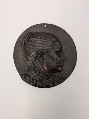 une image représentant un médaillon en bronze à l'effigie d'une femme