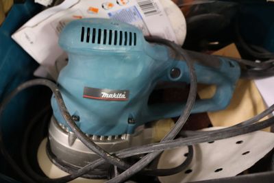 a blue electric sander sitting on top of a table
