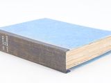 un livre bleu posé sur une table blanche