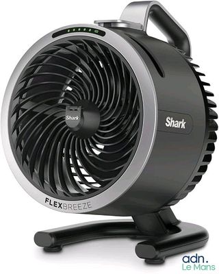 un gros plan d'un ventilateur noir et argenté posé sur un pied