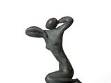 une statue de femme assise au sommet d'un rocher