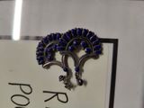 a picture of a brooch with blue stones on it