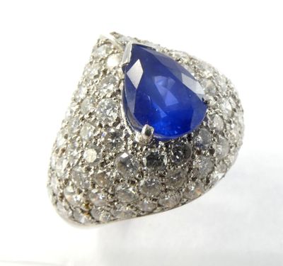 gros plan d'une bague en saphir bleu et diamant sur une surface blanche