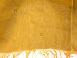 an image of a yellow scarf with fringes on a white surface