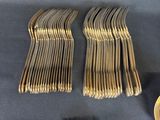 many forks and spoons laid out on a table
