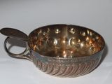a silver bowl with a spoon in it on a table