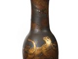 a black vase with a gold design on it