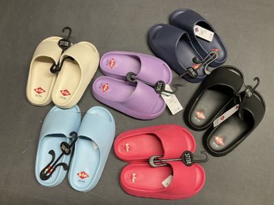 Plusieurs paires de pantoufles sont alignées sur une table