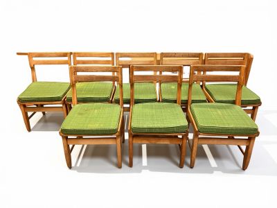 six chaises alignées, équipées de coussins verts
